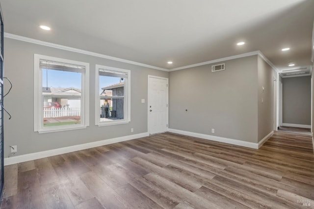 unfurnished living room with visible vents, baseboards, and crown molding