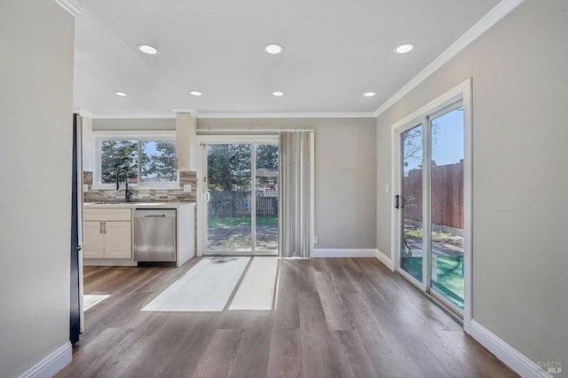 interior space featuring a healthy amount of sunlight, wood finished floors, baseboards, and a sink