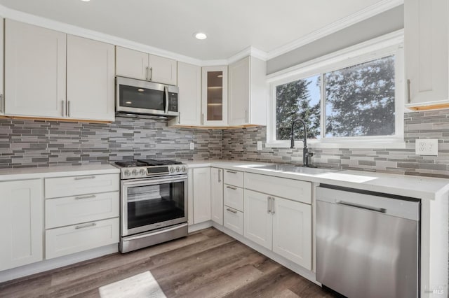 kitchen featuring a sink, decorative backsplash, appliances with stainless steel finishes, and light countertops