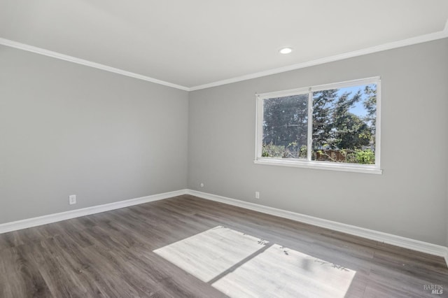 empty room with recessed lighting, crown molding, baseboards, and wood finished floors