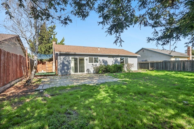 back of property with a lawn, a fenced backyard, and a patio area