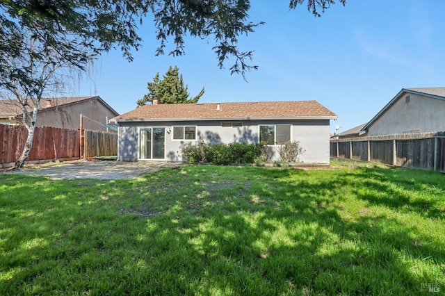 back of property featuring a yard, a patio, a fenced backyard, and a chimney