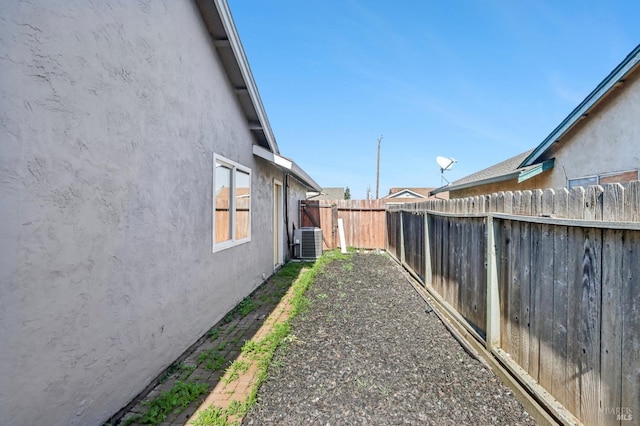 view of yard featuring central AC and fence