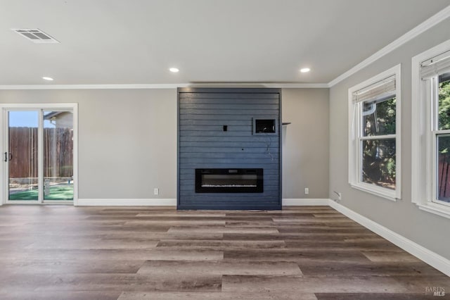 unfurnished living room with visible vents, ornamental molding, wood finished floors, a fireplace, and baseboards