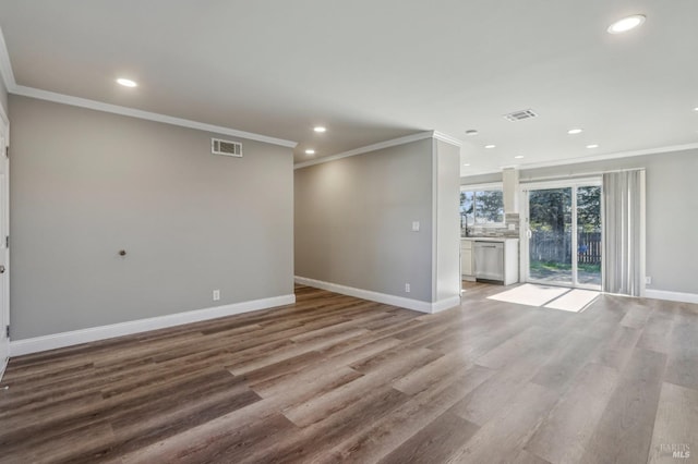 spare room with wood finished floors, baseboards, and visible vents