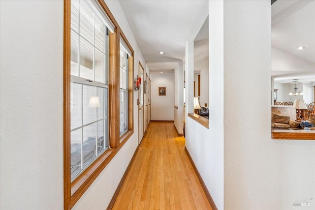 hall with light wood-style floors, recessed lighting, and baseboards