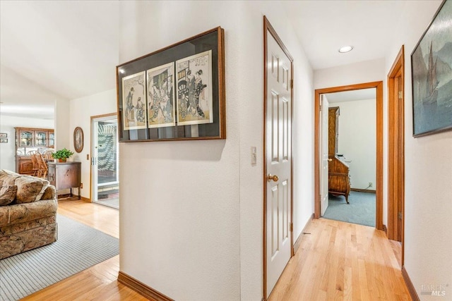 corridor with baseboards and light wood finished floors