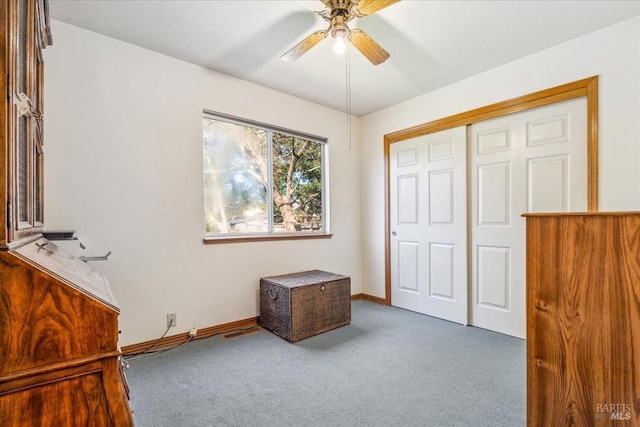 unfurnished bedroom with carpet, a closet, ceiling fan, and baseboards