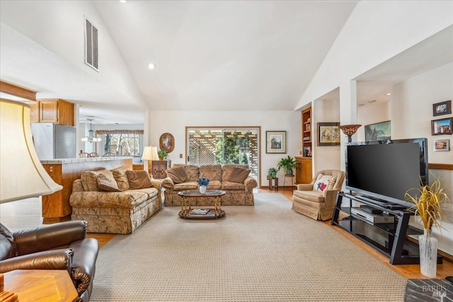 living room with high vaulted ceiling, recessed lighting, visible vents, and wood finished floors