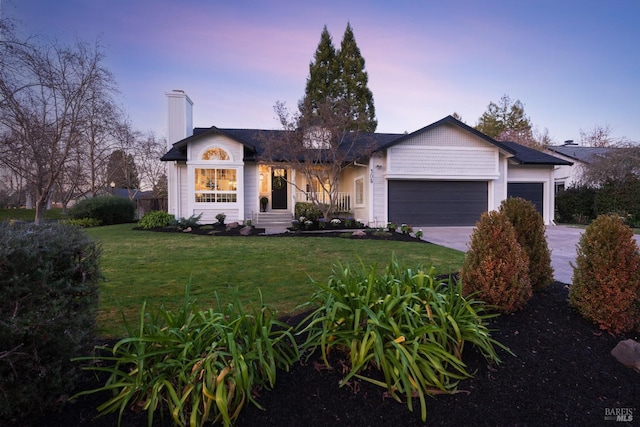 view of front of home with an attached garage, driveway, a front lawn, and a chimney