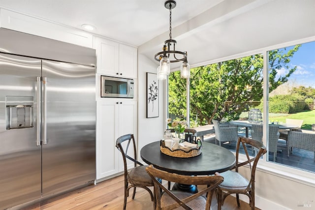 dining space with light wood-style floors and a chandelier