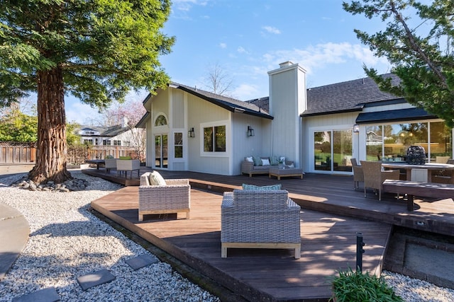 rear view of property with an outdoor hangout area, fence, roof with shingles, a wooden deck, and a chimney