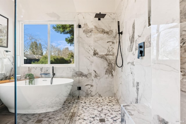 full bath with a marble finish shower and a freestanding bath