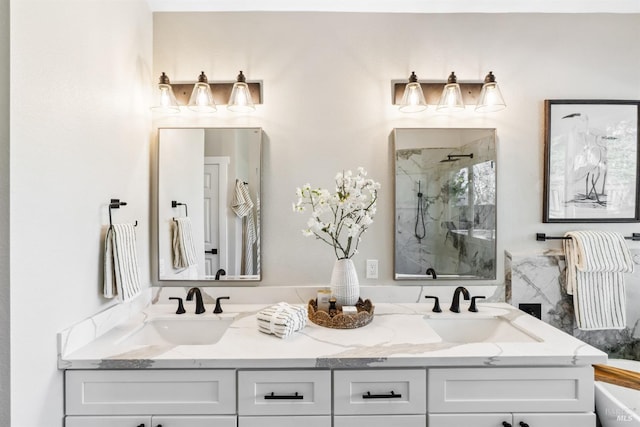 full bath with a sink, a marble finish shower, and double vanity