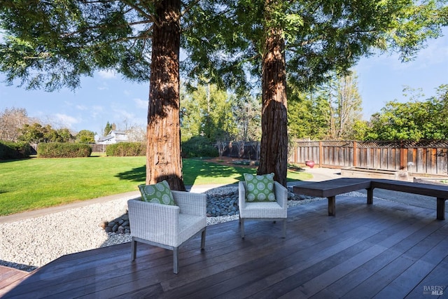 wooden deck featuring a lawn and a fenced backyard