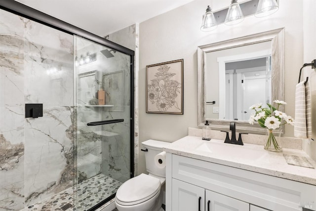 bathroom featuring a marble finish shower, vanity, and toilet