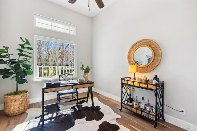 office area with wood finished floors, baseboards, and ceiling fan