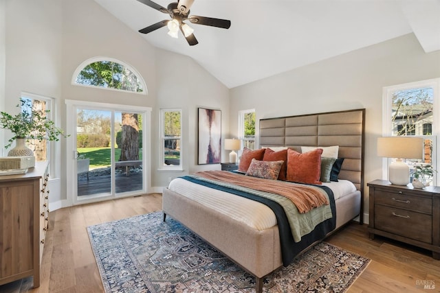 bedroom with access to outside, multiple windows, and light wood-style floors