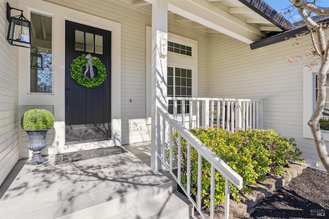 view of exterior entry featuring covered porch