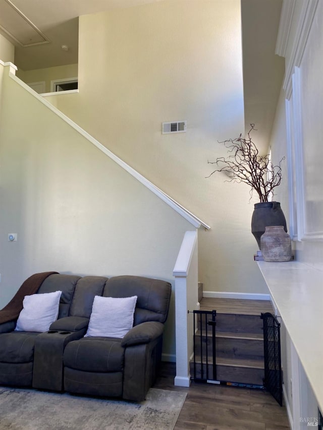 living area featuring baseboards, attic access, visible vents, and wood finished floors