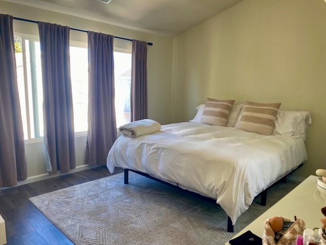 bedroom with multiple windows and wood finished floors