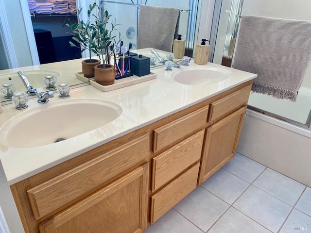 bathroom with bath / shower combo with glass door, tile patterned flooring, a sink, and double vanity