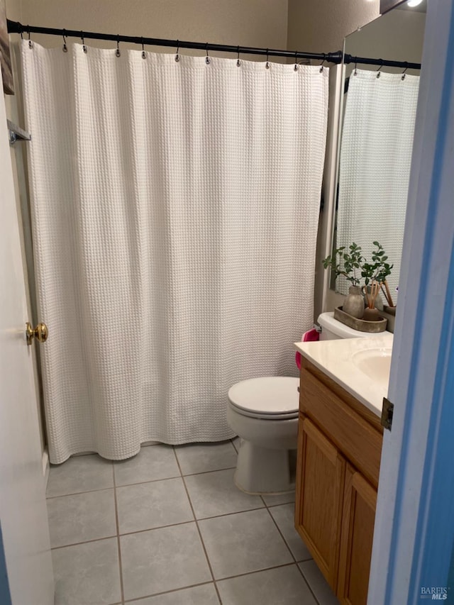 bathroom with toilet, tile patterned flooring, and vanity