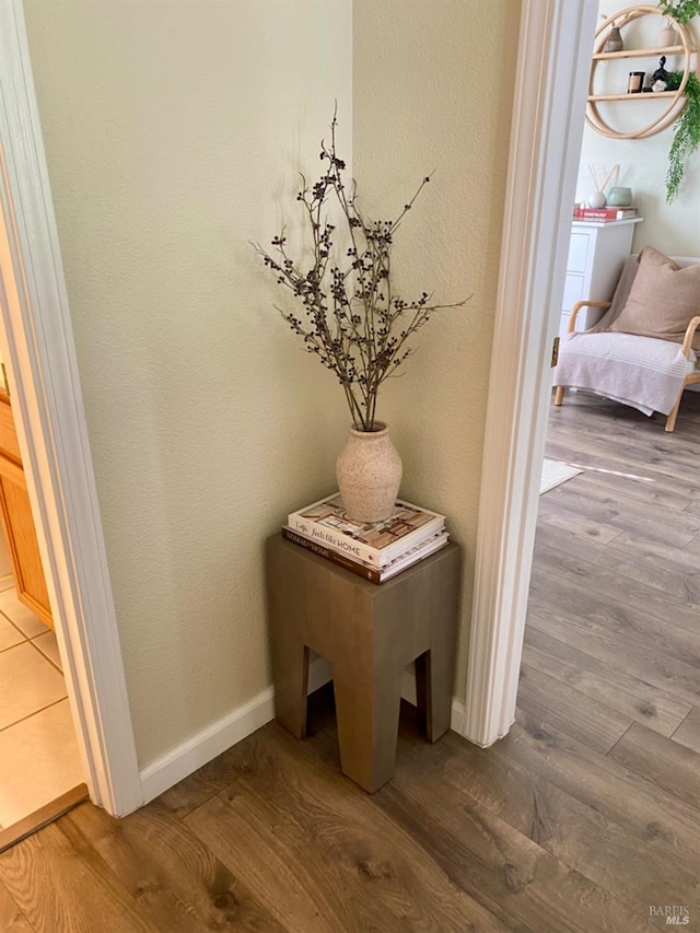 details featuring a textured wall, baseboards, and wood finished floors