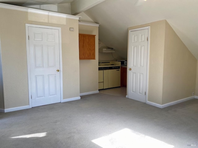 additional living space with vaulted ceiling with beams, light carpet, and baseboards