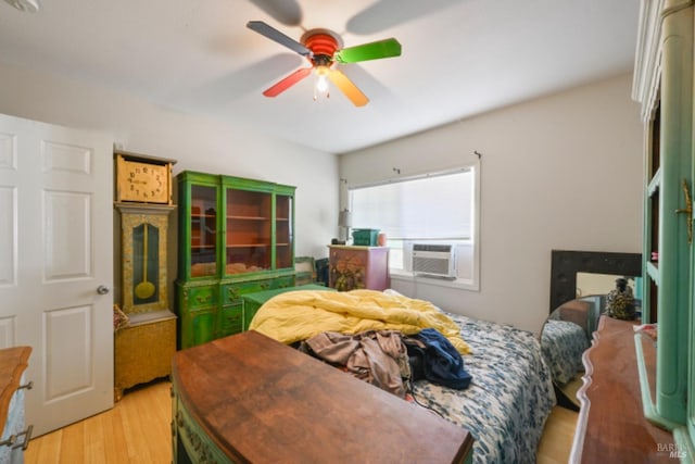 bedroom featuring cooling unit, ceiling fan, and light wood-style flooring