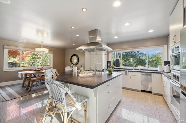 kitchen with recessed lighting, granite finish floor, dark countertops, and island range hood