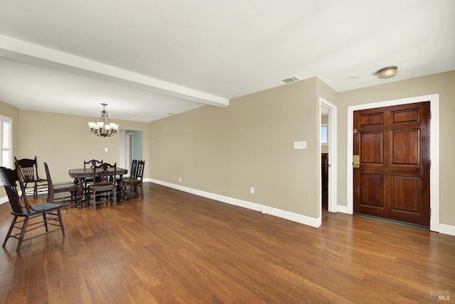 entrance foyer featuring dark wood-style floors, baseboards, beamed ceiling, and an inviting chandelier