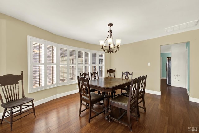 dining space with dark wood-style flooring, visible vents, a notable chandelier, and baseboards