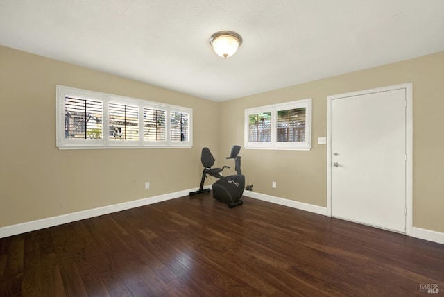 empty room with dark wood-type flooring and baseboards