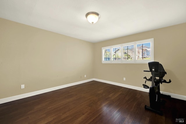 workout room with dark wood-style flooring and baseboards