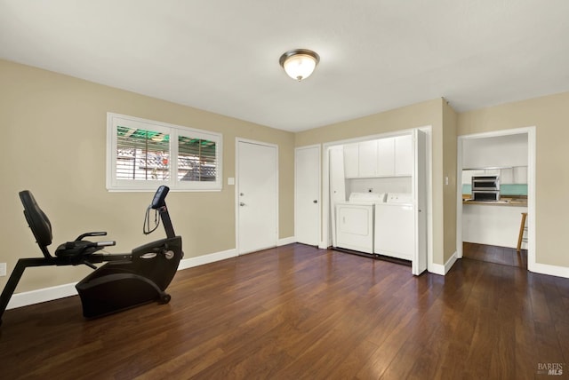 exercise area with washing machine and dryer, baseboards, and dark wood-style flooring