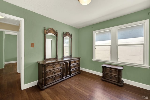 bedroom with dark wood-style flooring and baseboards