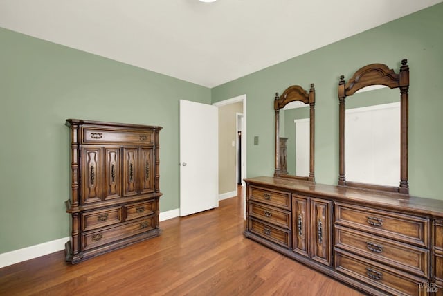 bedroom with baseboards and wood finished floors