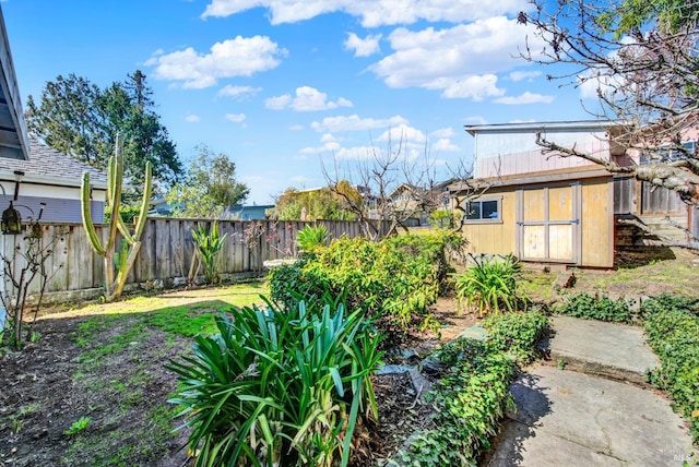 view of yard with a fenced backyard and an outbuilding