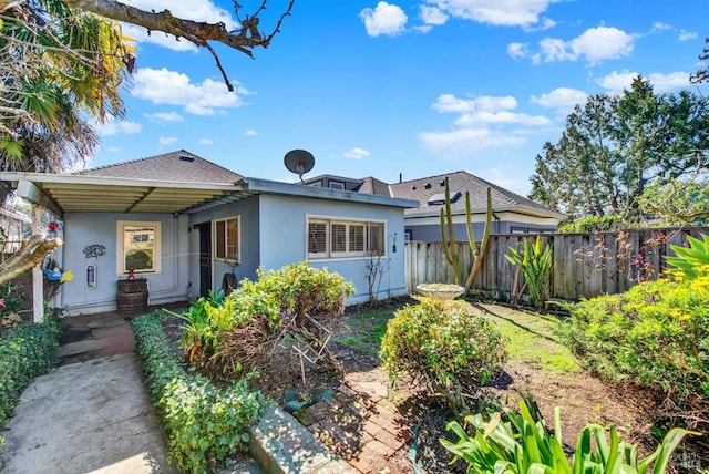 bungalow-style house with fence and stucco siding