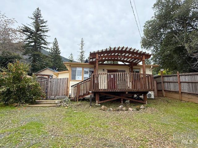 back of property with a deck, fence, and a pergola