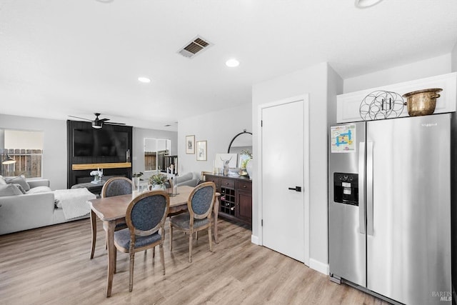 dining room featuring a wealth of natural light, visible vents, light wood-style flooring, and a ceiling fan