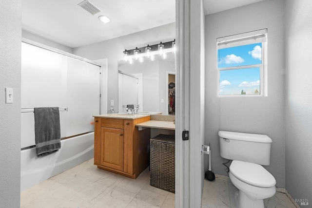 bathroom featuring toilet, visible vents, marble finish floor, and combined bath / shower with glass door