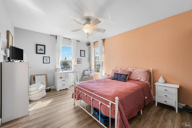 bedroom with baseboards, ceiling fan, and wood finished floors