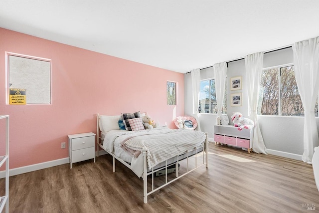 bedroom featuring wood finished floors and baseboards