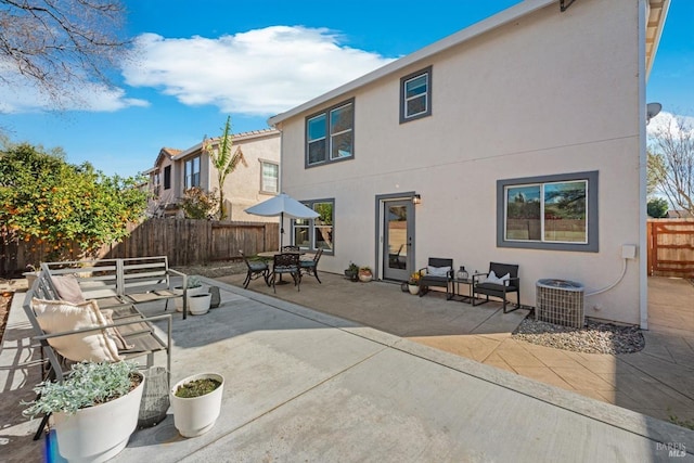 back of property with central AC unit, a patio area, a fenced backyard, and stucco siding