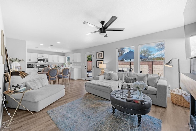 living area featuring recessed lighting, light wood-style flooring, and ceiling fan