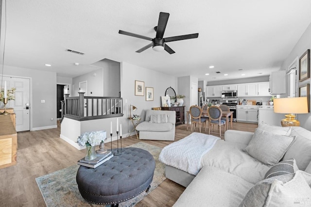 living area featuring visible vents, baseboards, light wood-type flooring, recessed lighting, and a ceiling fan