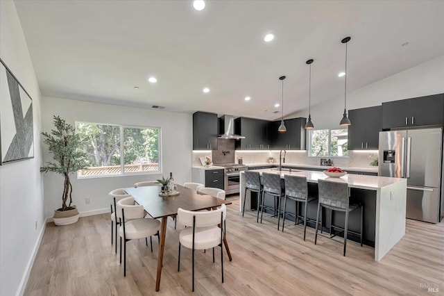 dining room with light wood-type flooring, baseboards, vaulted ceiling, and recessed lighting