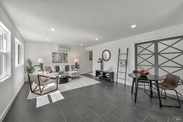 living area featuring baseboards, an AC wall unit, dark tile patterned flooring, and recessed lighting